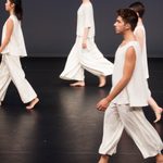 Dancers wearing white walking across the stage