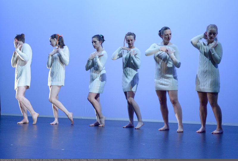 Dancers in white dresses standing in front of a blue background