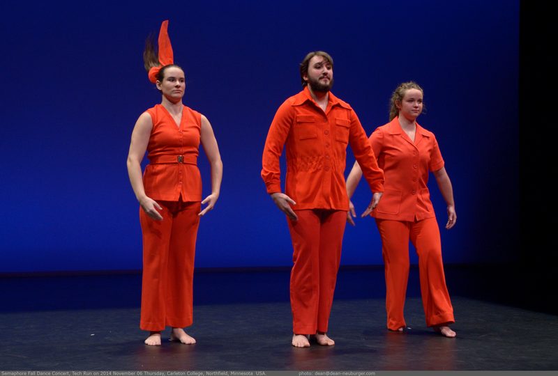 Three dancers wearing orange
