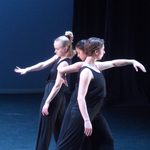 Three women in black dancing together