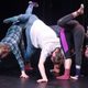 Dancers upside-down with one leg up huddled together