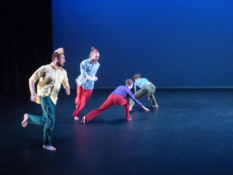 Dancers wearing colorful clothes on moving on stage
