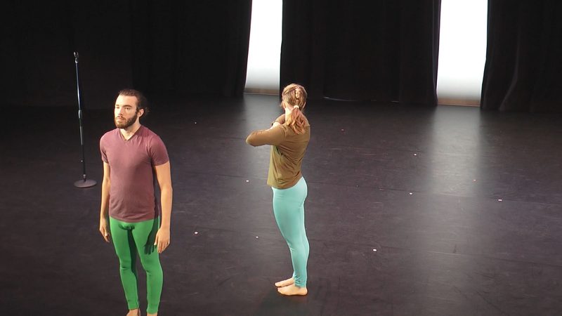 Two dancers standing on stage.