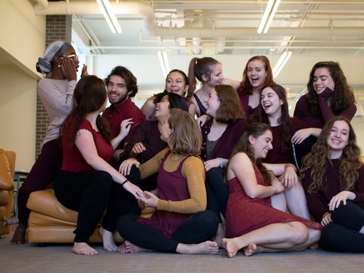 Performers of Semaphore sitting for an informal group photo. Students laugh and make silly faces.