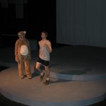 A person in a bear costume watching a man running in place