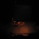 Dancers laying on a dimly lit stage