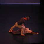 A man pulling a woman up who is laying on the floor