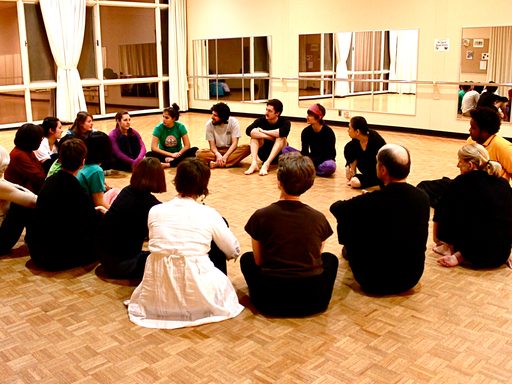 Dancers sitting in a circle during a dance workshop with Eiko Otake