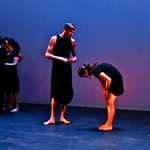 Dancers wearing black and standing on stage