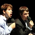 Two men speaking into microphones