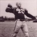 Schmucker winds up to throw a football in full uniform