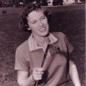 Burch smiles holding a golf club