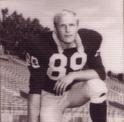 Jacobsen kneels with his hand resting on his football helmet