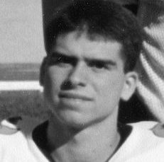 Cote looks at the camera with a straight face, West Gymnasium in the background