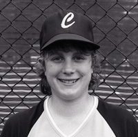Muller posed in front of a chain link fence, smiling at the camera