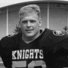 Schuldt (#50) poses smiling with West Gymnasium in the background