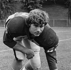 Birkholz kneels on the football field