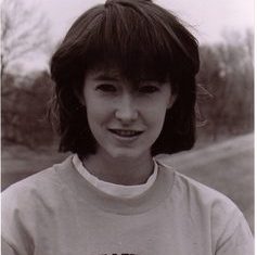 Kelly smiles for the camera wearing a track sweatshirt