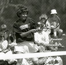 Hunt jumps to knock the tennis ball back over the net with her racquet