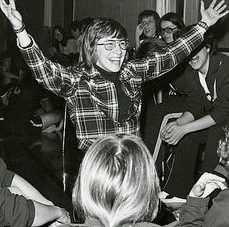 Matsen poses, grinning, with arms above her head surrounded by players in uniform