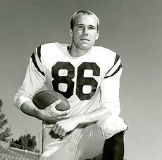 Weshinskey, #86, poses kneeled with a football tucked under his right arm
