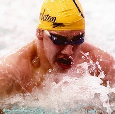 Harper swims breast stroke in bright yellow swim cap