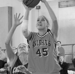 Barrymore taking a shot, holding the basketball over her head, defense close by