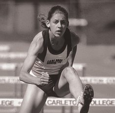 Helquist humps over a hurdle at an outdoor track meet