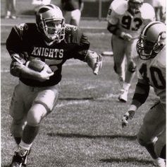 Hanks runs past defensive opponents with the football rucked under his right arm