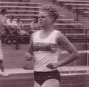 Scherer runs on the outdoor track, bleachers in the background