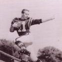 Dickinson poses jumping in the air holding a football