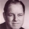 a headshot of Powell, who has a small smile