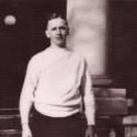 Cowles stands in front of a building in a white sweater