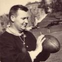 Coach Hass demonstrates something holding a football