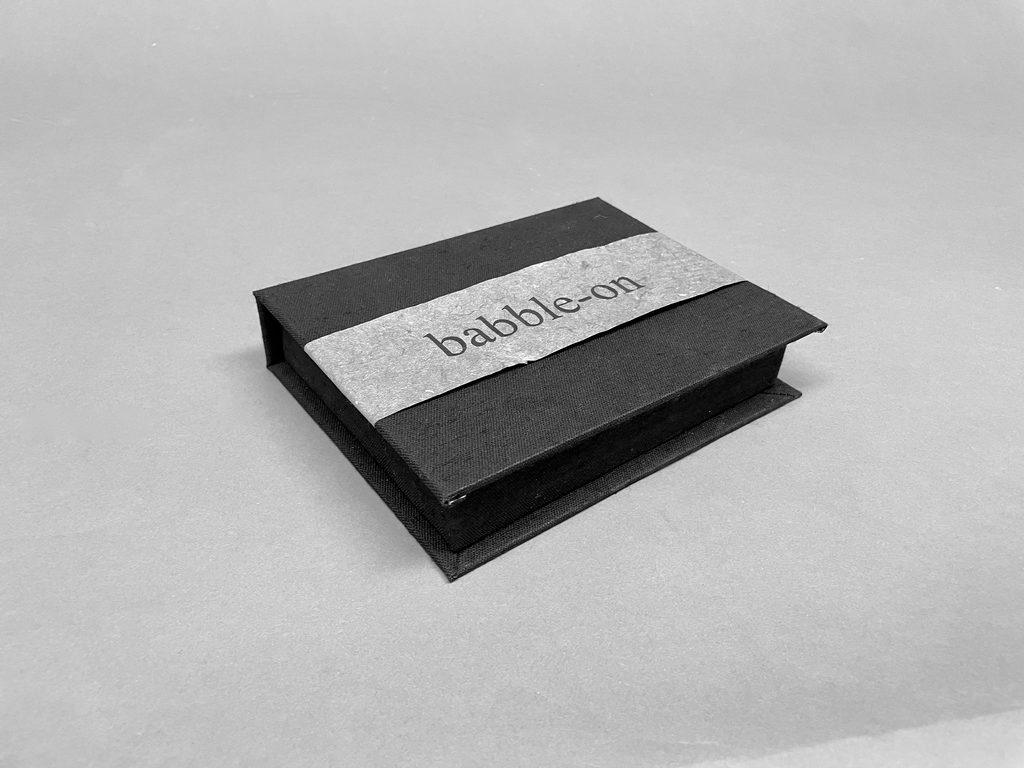 closed portfolio box with a ribbon labeled babble-on