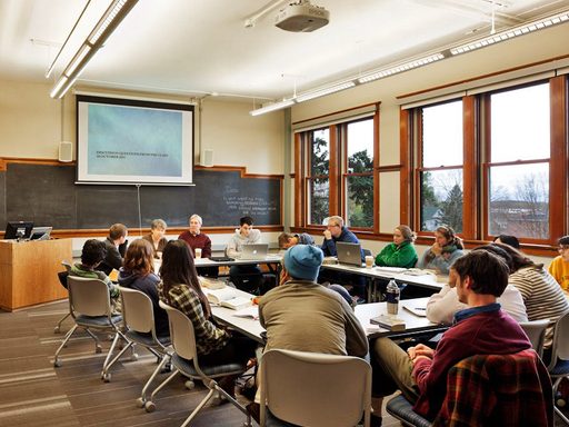 Students sit around a discussion table in a classroom