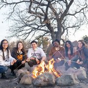 students roasting marshmallows over fire