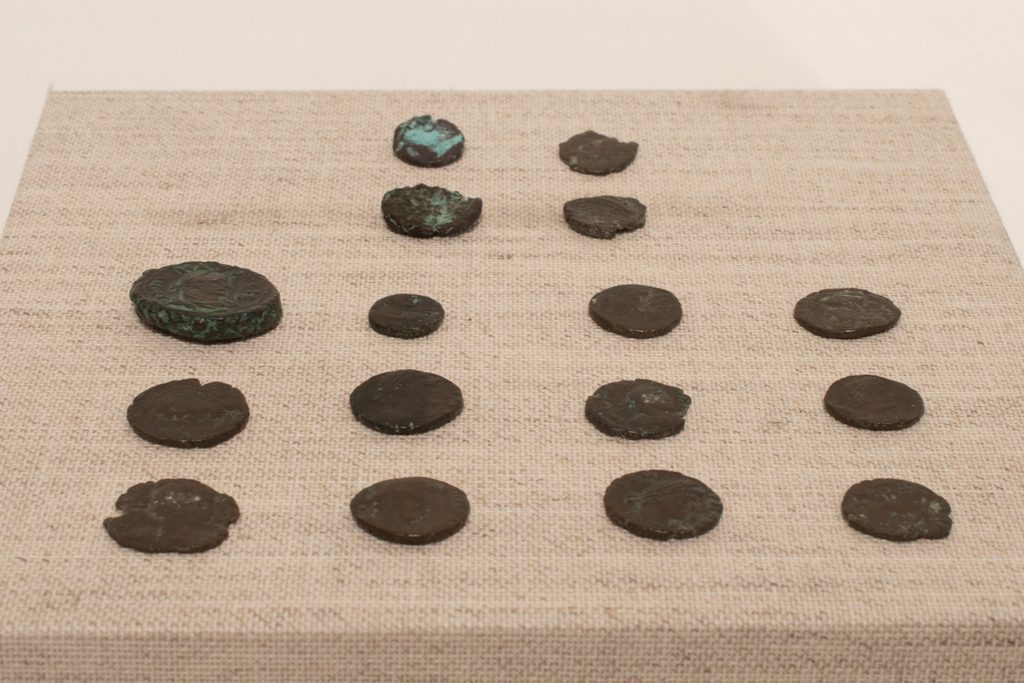 Students made coins sit in rows on top of a tan platform.