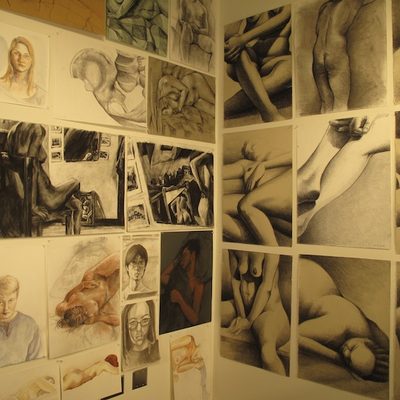 A series of figure drawings posted on two adjoining walls