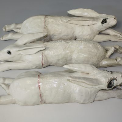 Three ceramic rabbits with human hands
