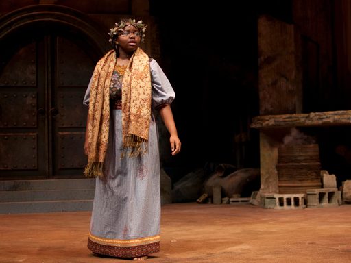 A student on stage in a theatrical production