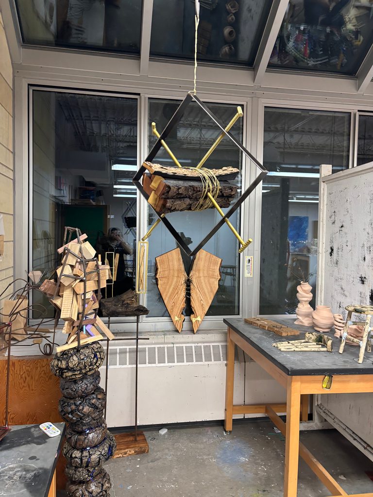 Two sculptures in a studio. Artwork is crafted from wood, brass flat stock, brass wire, rebar, artificial gold leaf, and steel mounting hardware