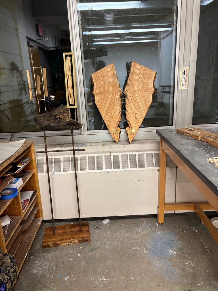 Sculpture in a studio: artwork is crafted from scrap wood, steel flat stock, threaded rod, rebar, and spray paint