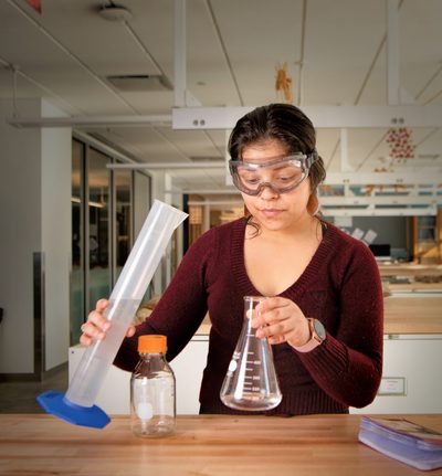 Denyse Marquez Sanchez ’21 holds a graduated cylinder and a conical flask