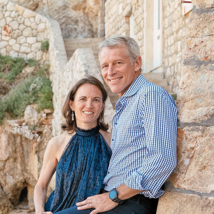 Susan and Whitney Tilson posing next to stone wall