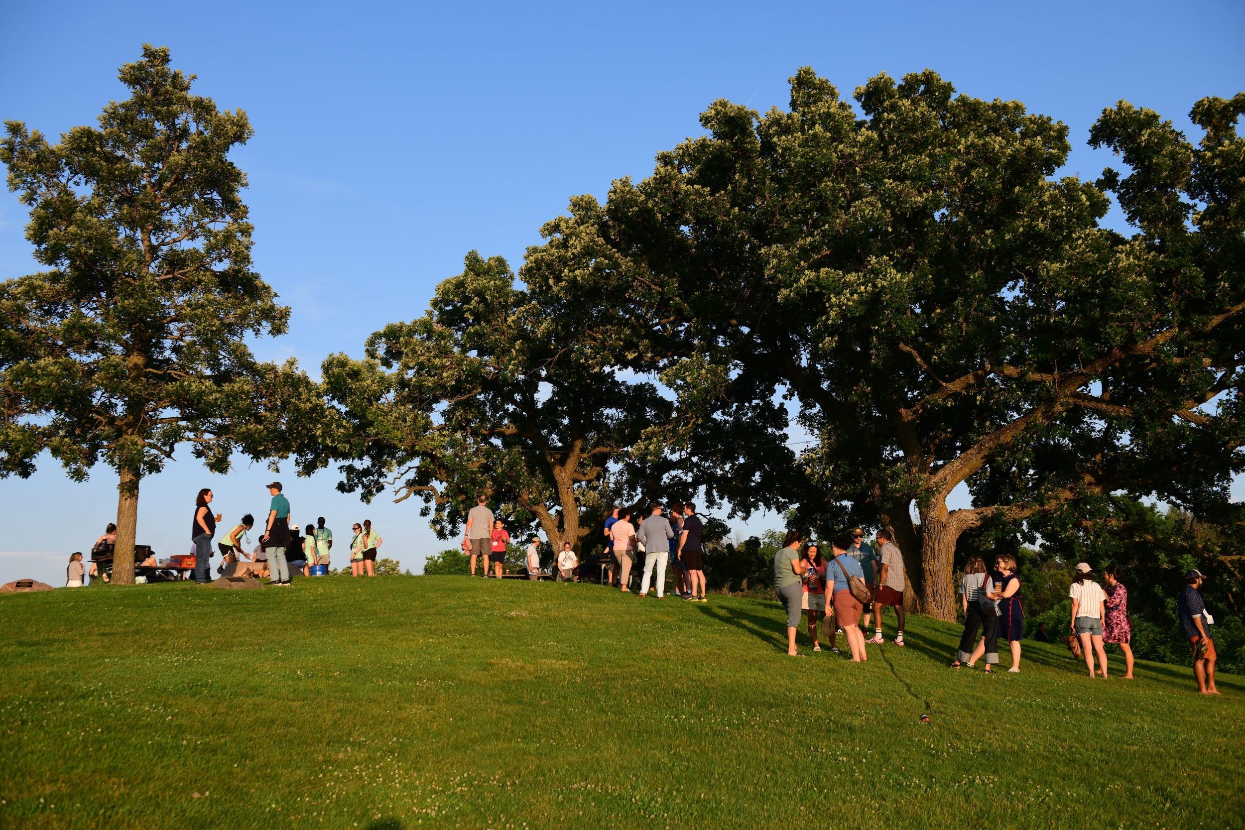 People socializing on the Hill of Three Oaks