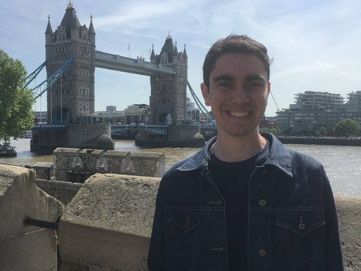 A man poses in front of Tower Bridge in London